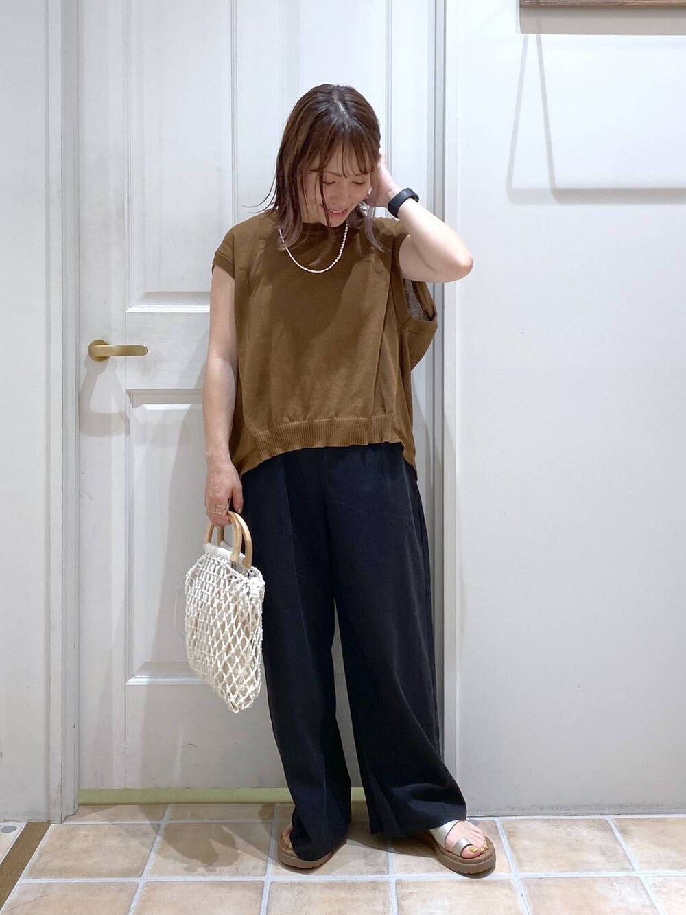 その他のサンダル、ブラック系のその他パンツ、ホワイト系のハンドバッグを着用したレディースの春コーディネートの4枚目の写真