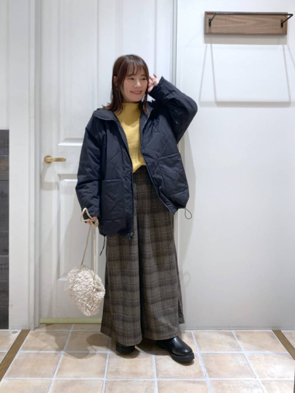 ブラック系のブーツ、イエロー系のニット/セーター、その他のその他アウターを着用したレディースの秋コーディネートの2枚目の写真