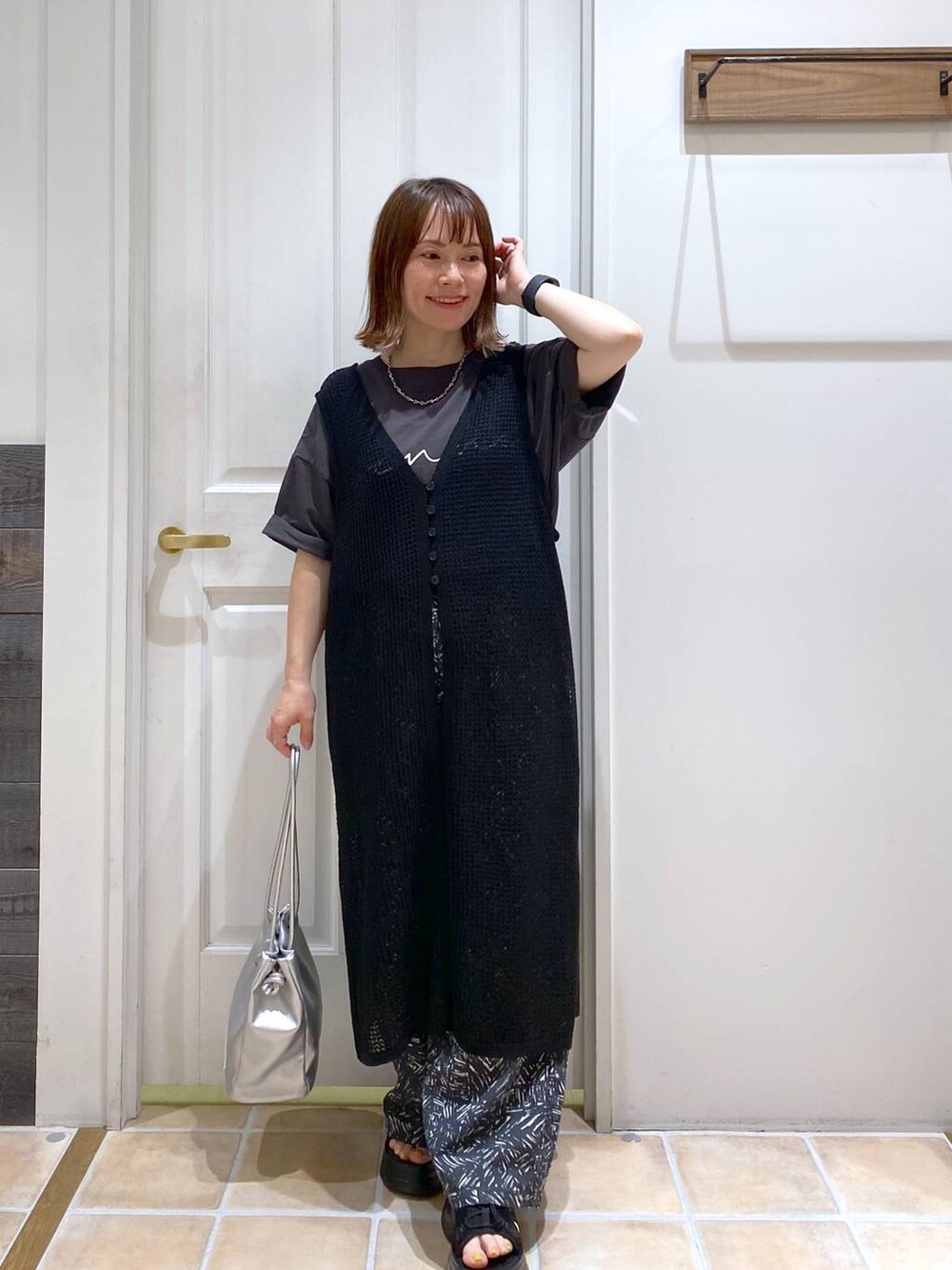 ブラック系のサンダル、ホワイト系のタンクトップ、その他のトートバッグを着用したレディースの夏コーディネートの3枚目の写真