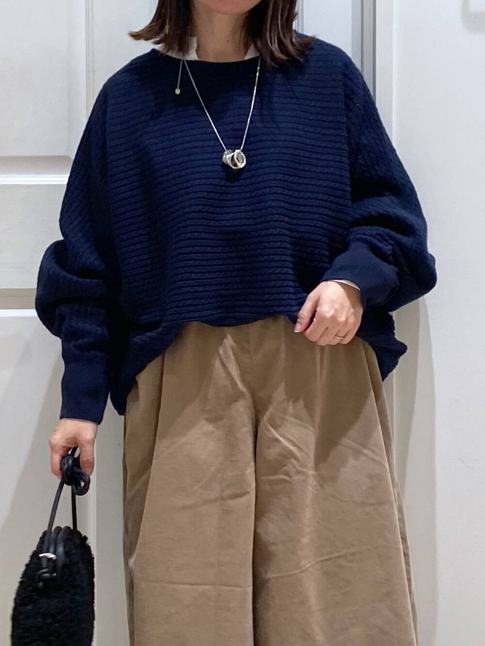 ベージュ系のその他パンツ、ブラック系のブーツ、ブルー系のニット/セーターを着用したレディースの秋コーディネートの4枚目の写真