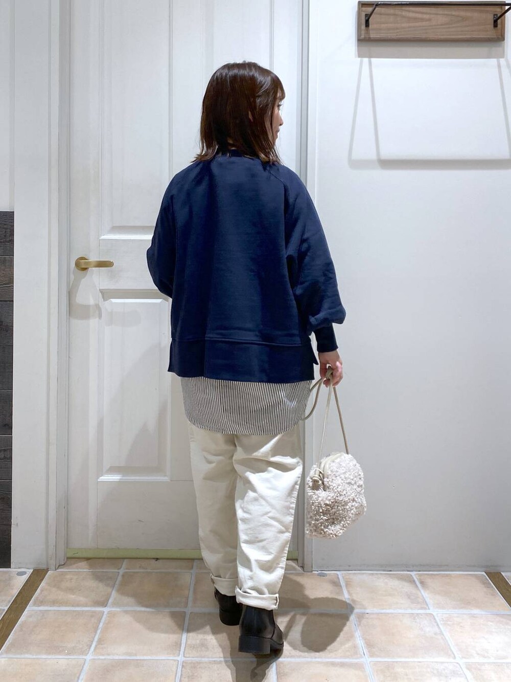 ブルー系のスウェット、ホワイト系のその他パンツ、ブラック系のブーツを着用したレディースの秋コーディネートの7枚目の写真