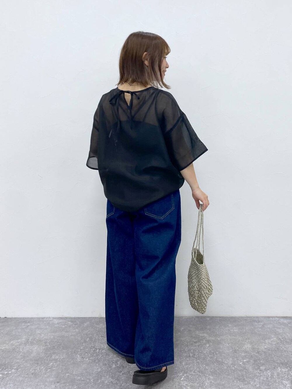 ブラック系のTシャツ/カットソー、ブラック系のサンダル、その他のハンドバッグを着用したレディースの夏コーディネートの7枚目の写真