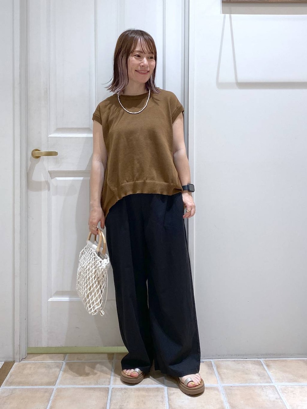 その他のサンダル、ブラック系のその他パンツ、ホワイト系のハンドバッグを着用したレディースの春コーディネートの3枚目の写真