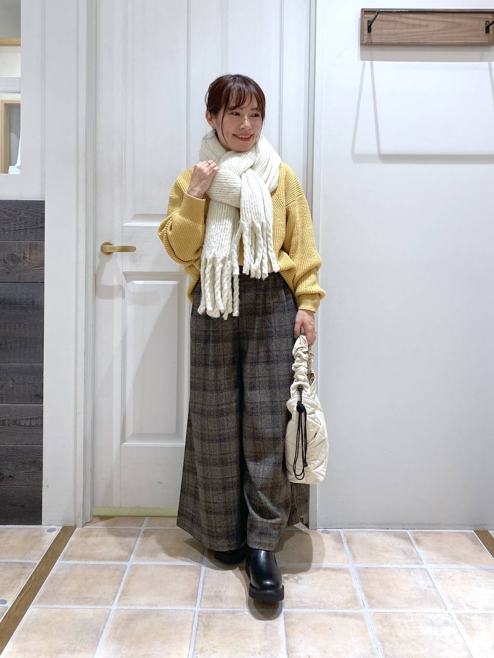 イエロー系のニット/セーター、その他のその他パンツ、ベージュ系のトートバッグを着用したレディースの秋コーディネートの3枚目の写真