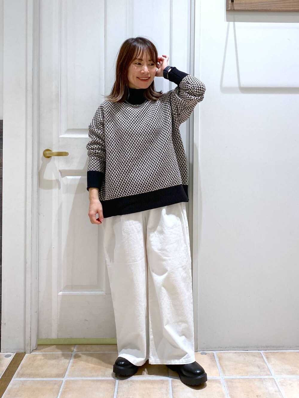 ブラック系のブーツ、ホワイト系のその他パンツ、その他のニット/セーターを着用したレディースの冬コーディネートの2枚目の写真