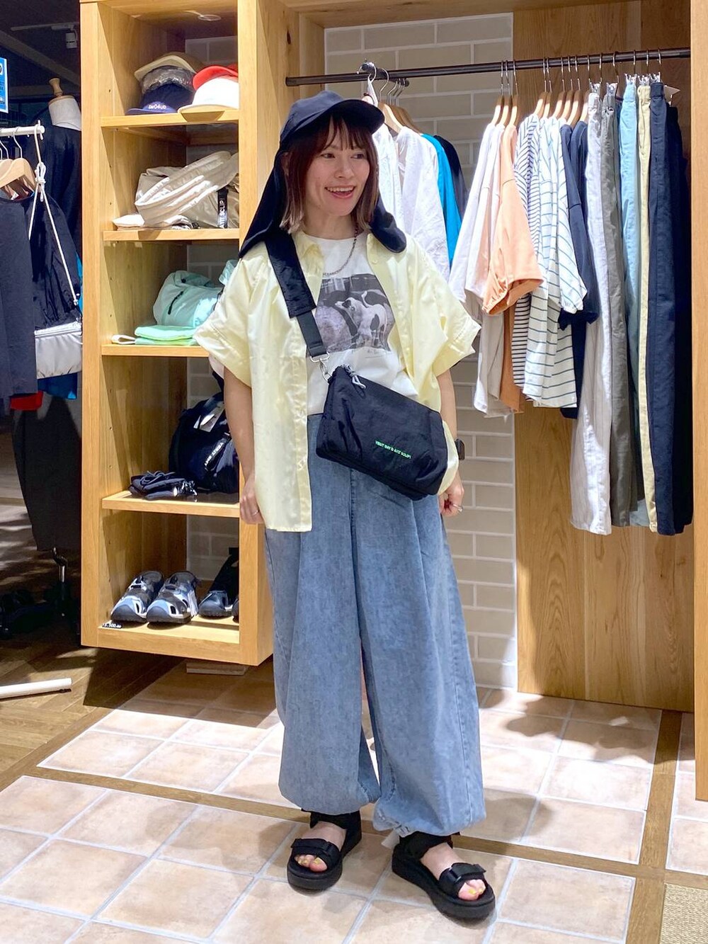 イエロー系のシャツ/ブラウス、ブラック系のサンダル、その他のTシャツ/カットソーを着用したレディースの春コーディネートの3枚目の写真