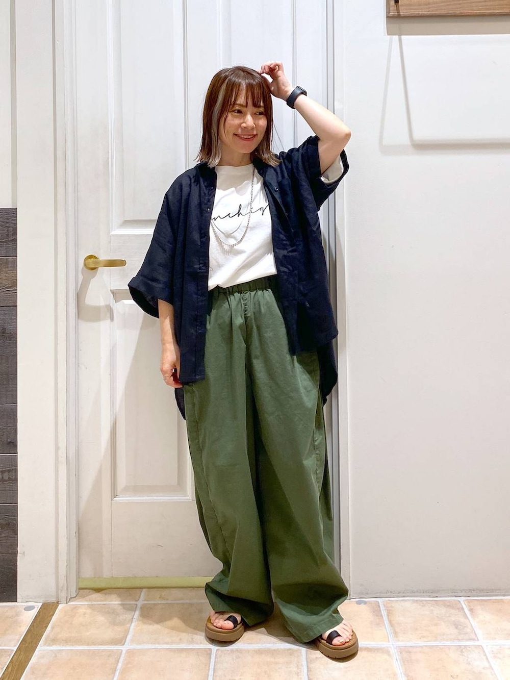 ブラック系のサンダル、ブラック系のシャツ/ブラウス、その他のTシャツ/カットソーを着用したレディースの夏コーディネートの2枚目の写真