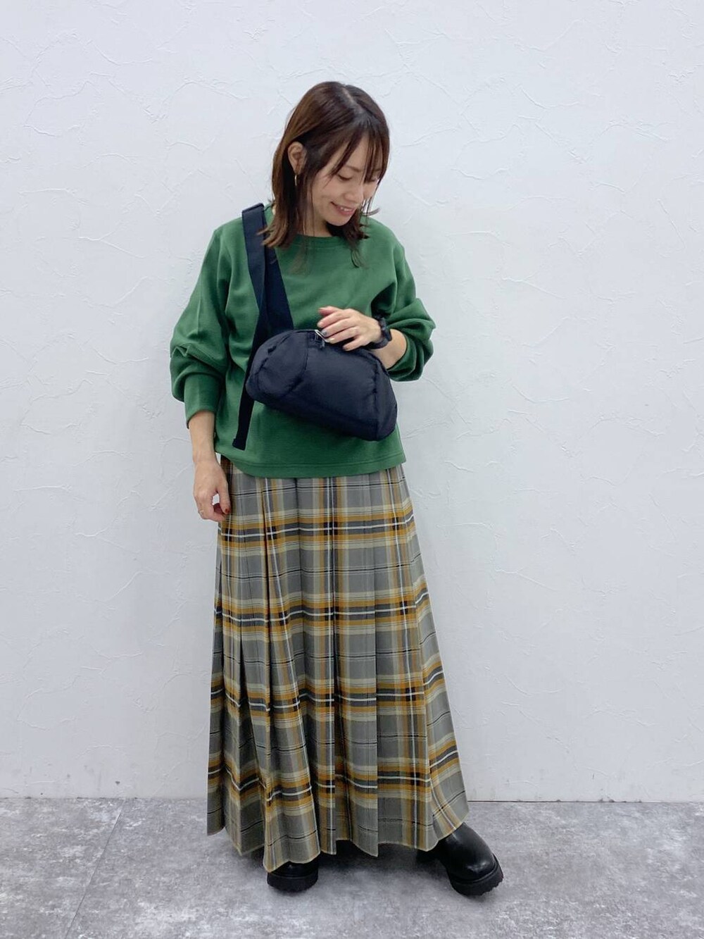 ブラック系のブーツ、ブラック系のショルダーバッグ、その他のスカートを着用したレディースの秋コーディネートの4枚目の写真