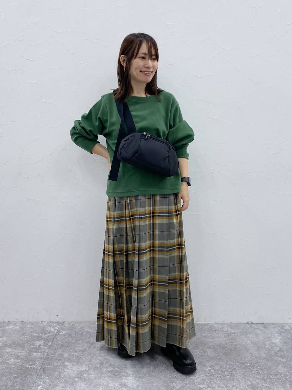 ブラック系のブーツ、ブラック系のショルダーバッグ、その他のスカートを着用したレディースの秋コーディネートの2枚目の写真