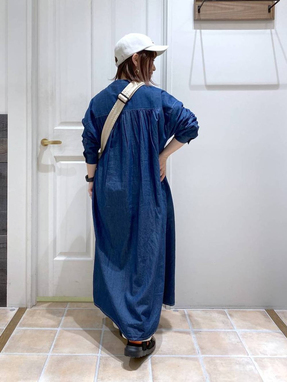 ブラック系のサンダル、ホワイト系のショルダーバッグ、ブルー系のワンピースを着用したレディースの春コーディネートの6枚目の写真