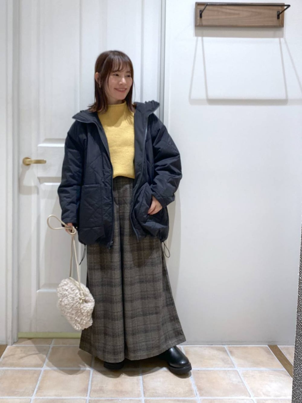 ブラック系のブーツ、イエロー系のニット/セーター、その他のその他アウターを着用したレディースの秋コーディネートの3枚目の写真