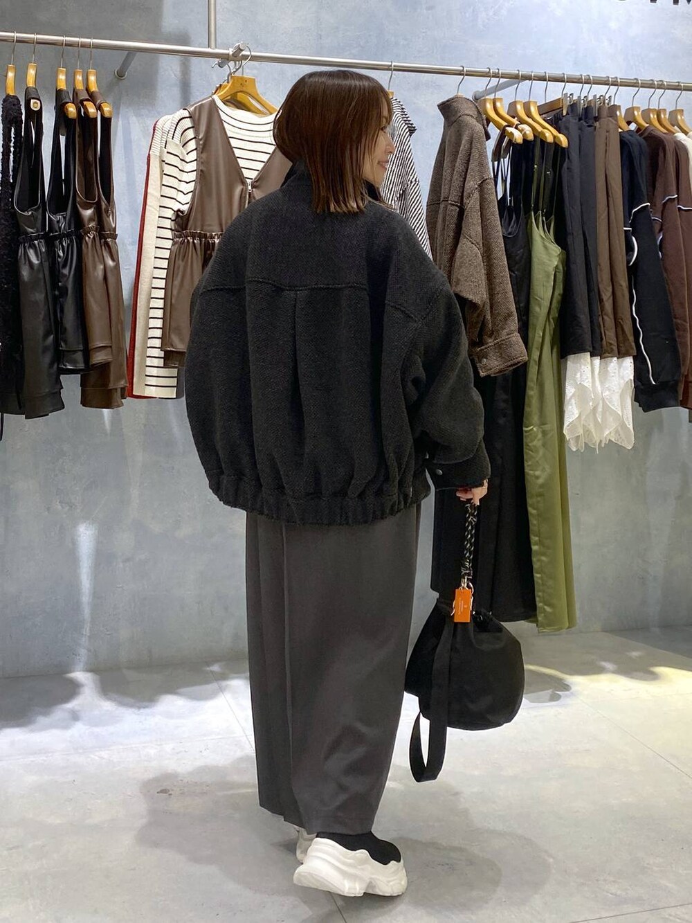 ブラック系のショルダーバッグ、ブラック系のニット/セーター、ホワイト系のニット/セーターを着用したレディースの秋コーディネートの5枚目の写真