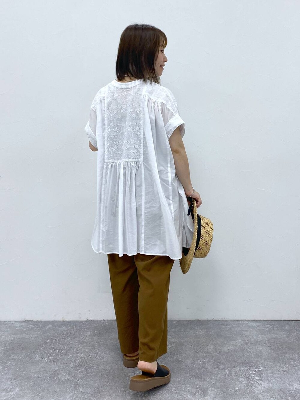 ブラウン系のその他パンツ、ブラック系のサンダル、ホワイト系のシャツ/ブラウスを着用したレディースの夏コーディネートの5枚目の写真