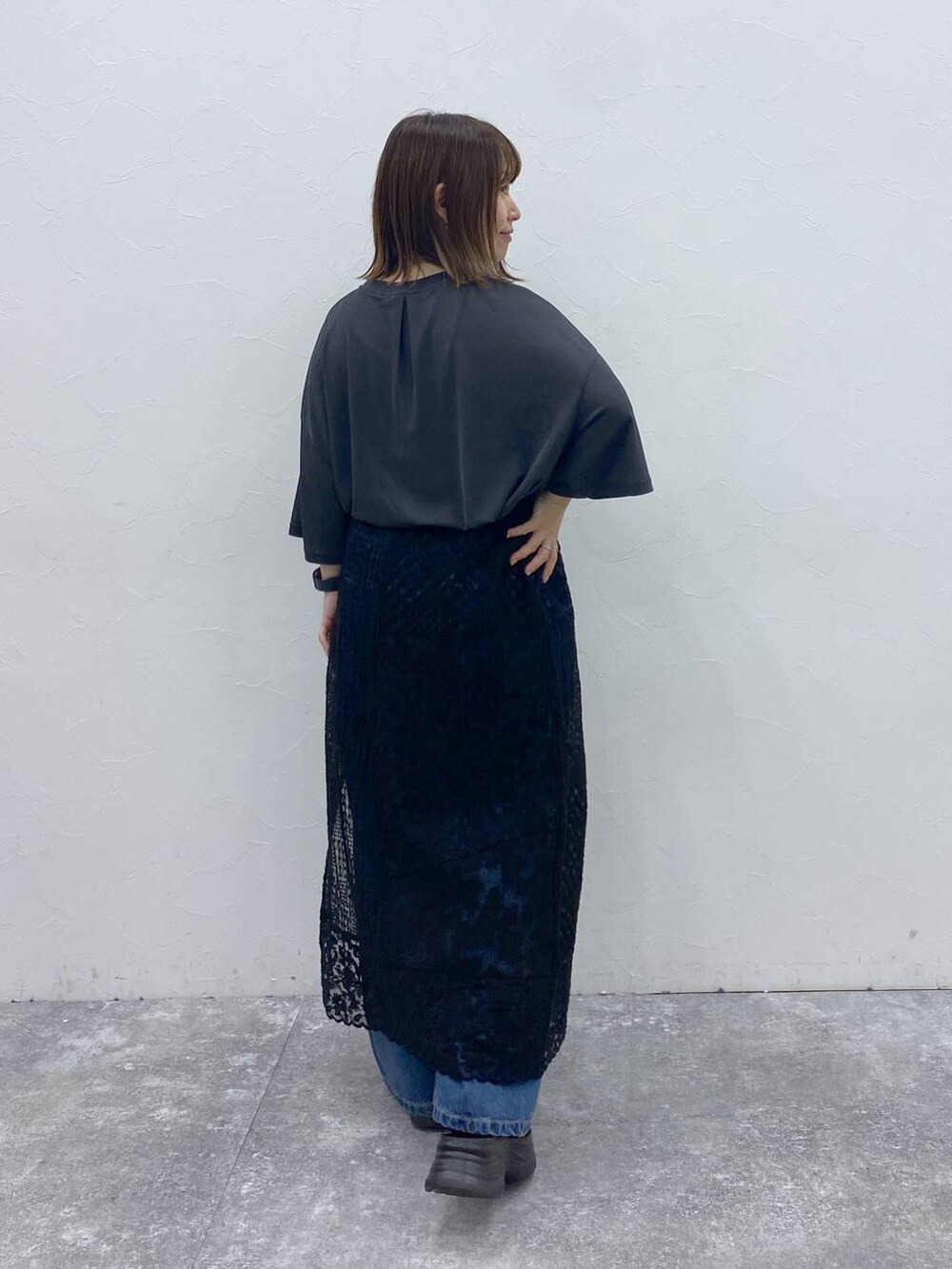 ブラック系のサンダル、ブルー系のデニムパンツ、ブラック系のスカートを着用したレディースの秋コーディネートの5枚目の写真