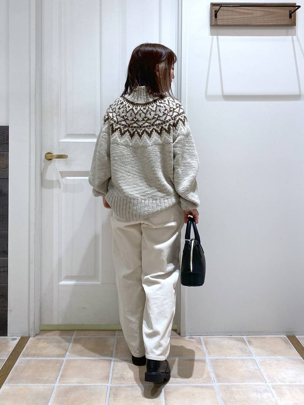 ホワイト系のその他パンツ、ブラック系のブーツ、ブラック系のショルダーバッグを着用したレディースの秋コーディネートの6枚目の写真