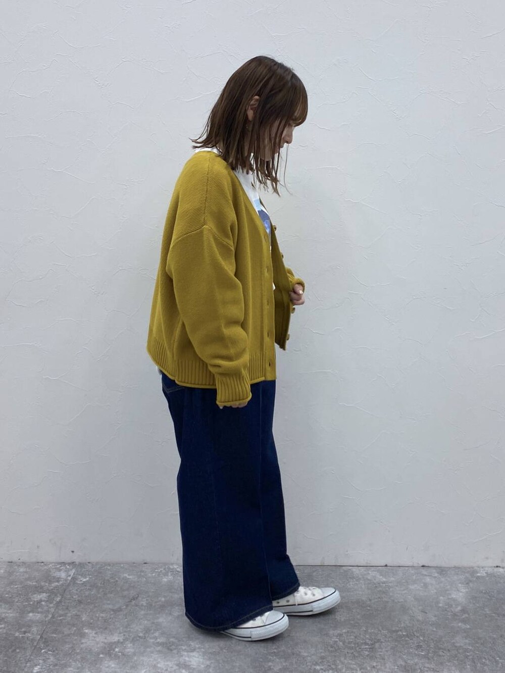 ブルー系のデニムパンツ、イエロー系のカーディガン/ボレロ、その他のTシャツ/カットソーを着用したレディースの秋コーディネートの5枚目の写真