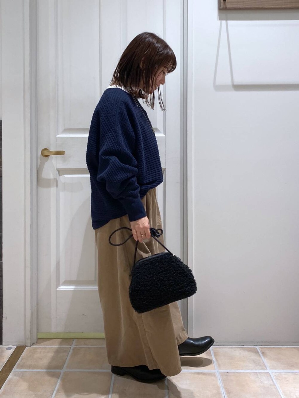 ベージュ系のその他パンツ、ブラック系のブーツ、ブルー系のニット/セーターを着用したレディースの秋コーディネートの6枚目の写真