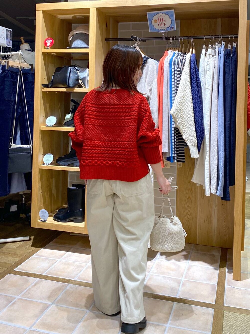 ブラック系のブーツ、ベージュ系のハンドバッグ、シルバー系のネックレスを着用したレディースの秋コーディネートの6枚目の写真