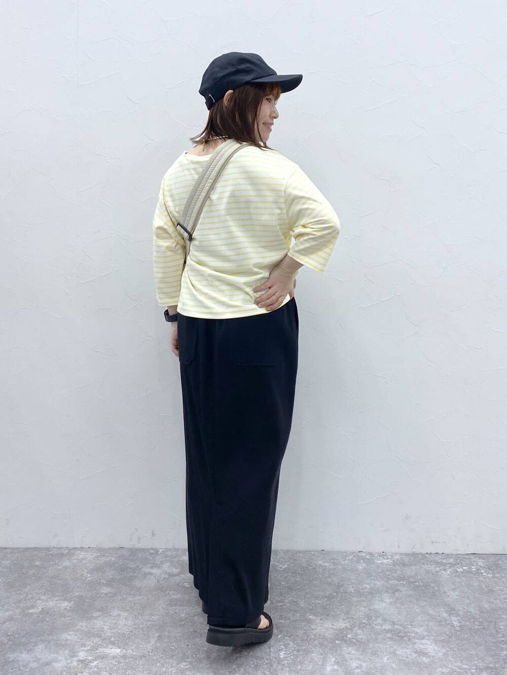 ホワイト系のショルダーバッグ、ブラック系のスカート、シルバー系のネックレスを着用したレディースの春コーディネートの6枚目の写真