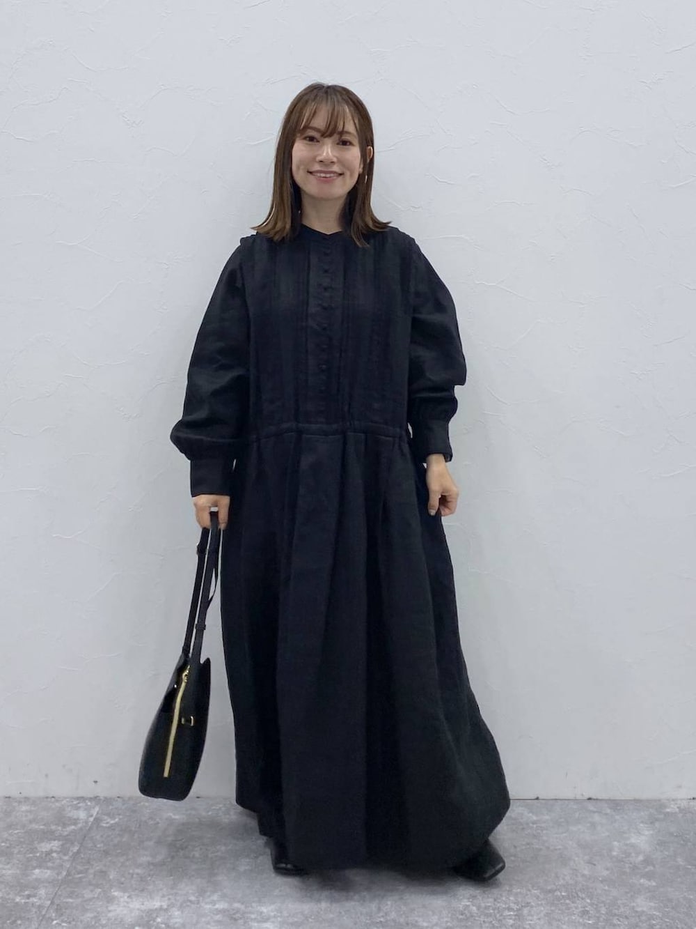 ブラック系のブーツ、ブラック系のショルダーバッグ、ブラック系のワンピースを着用したレディースの夏コーディネートの2枚目の写真