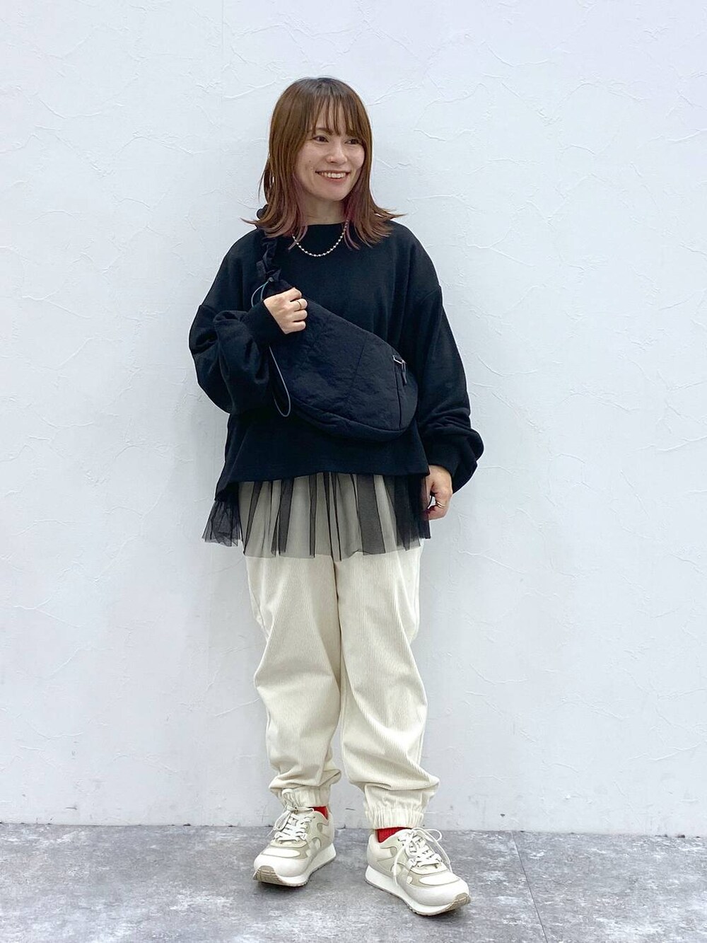ホワイト系のスニーカー、ブラック系のショルダーバッグ、ブラック系のTシャツ/カットソーを着用したレディースの秋コーディネートの4枚目の写真
