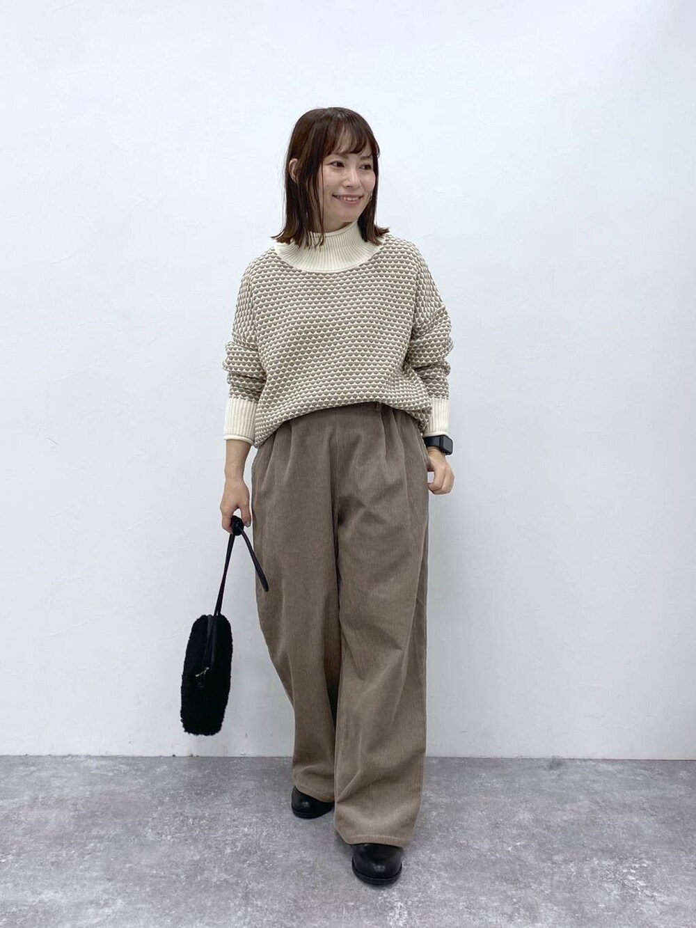 グレー系のその他パンツ、ブラック系のブーツ、ホワイト系のニット/セーターを着用したレディースの秋コーディネートの3枚目の写真