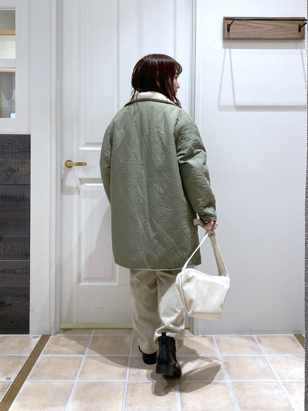 グリーン系のその他アウター、ブラック系のブーツ、グレー系のその他パンツを着用したレディースの冬コーディネートの6枚目の写真