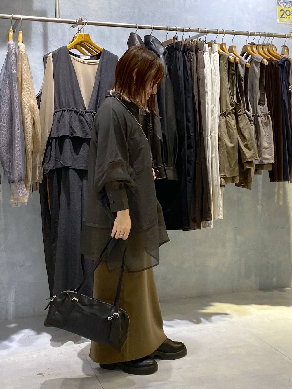 グレー系のシャツ/ブラウス、ブラック系のスカート、ブラック系のサンダルを着用したレディースの秋コーディネートの4枚目の写真