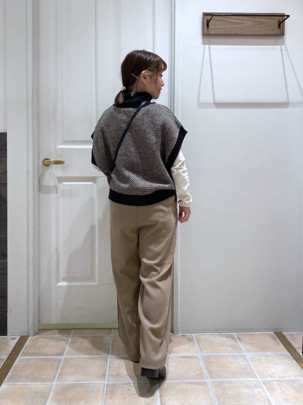 ホワイト系のTシャツ/カットソー、ブラック系のブーツ、ブラック系のベストを着用したレディースの冬コーディネートの6枚目の写真