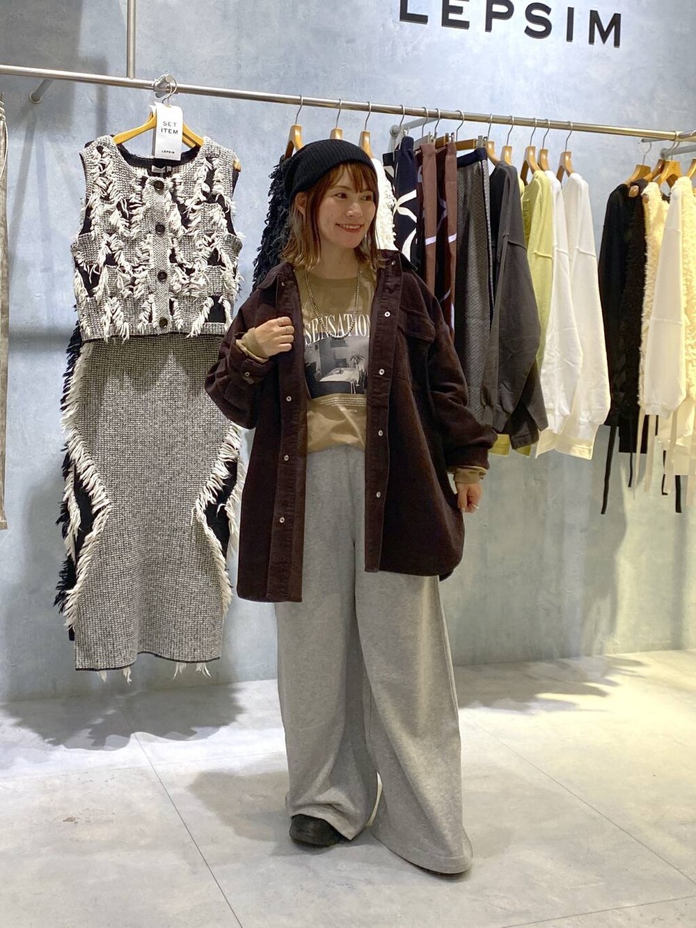 グレー系のスウェットパンツ、ブラック系のスニーカー、ブラウン系のシャツ/ブラウスを着用したレディースの秋コーディネートの2枚目の写真