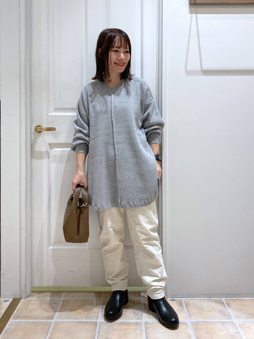 ホワイト系のその他パンツ、ブラック系のブーツ、ブラウン系のショルダーバッグを着用したレディースの秋コーディネートの3枚目の写真