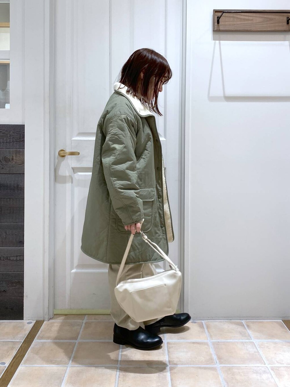 グリーン系のその他アウター、ブラック系のブーツ、グレー系のその他パンツを着用したレディースの冬コーディネートの5枚目の写真