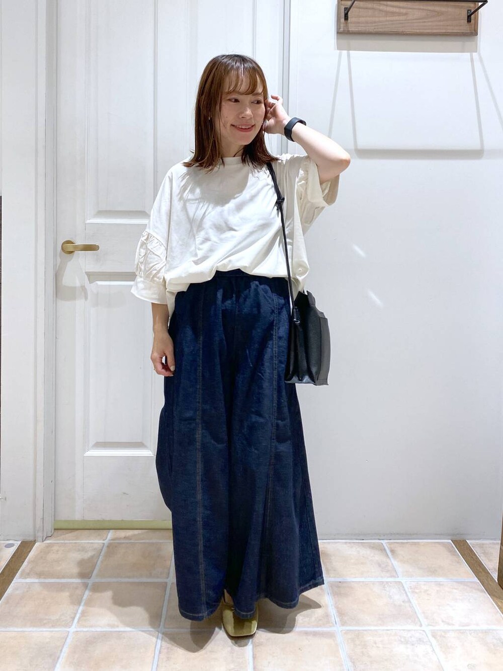 ホワイト系のTシャツ/カットソー、ブルー系のデニムパンツ、グリーン系のパンプスを着用したレディースの夏コーディネートの2枚目の写真