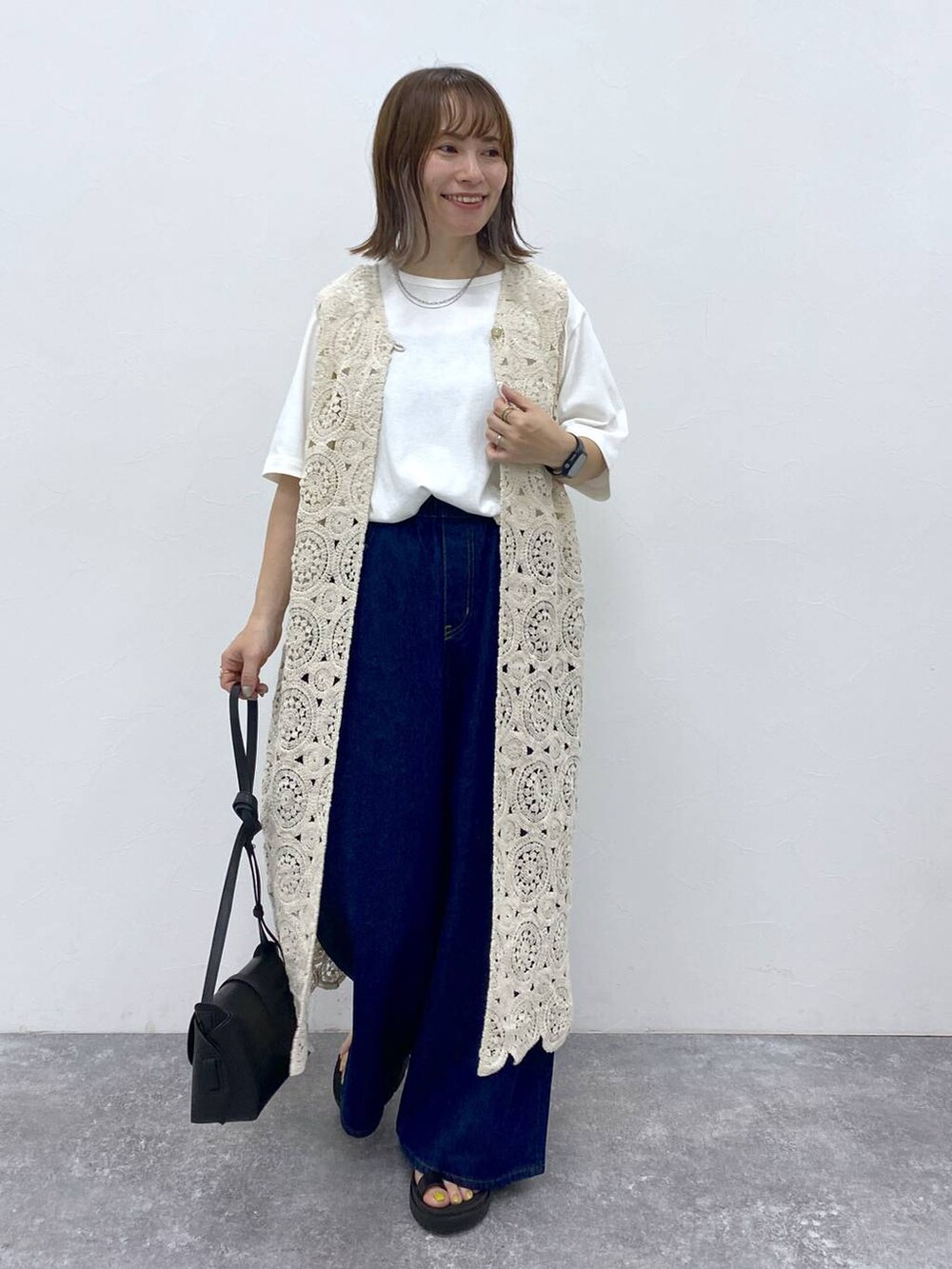 ブラック系のサンダル、ホワイト系のTシャツ/カットソー、ブラック系のショルダーバッグを着用したレディースの夏コーディネートの3枚目の写真