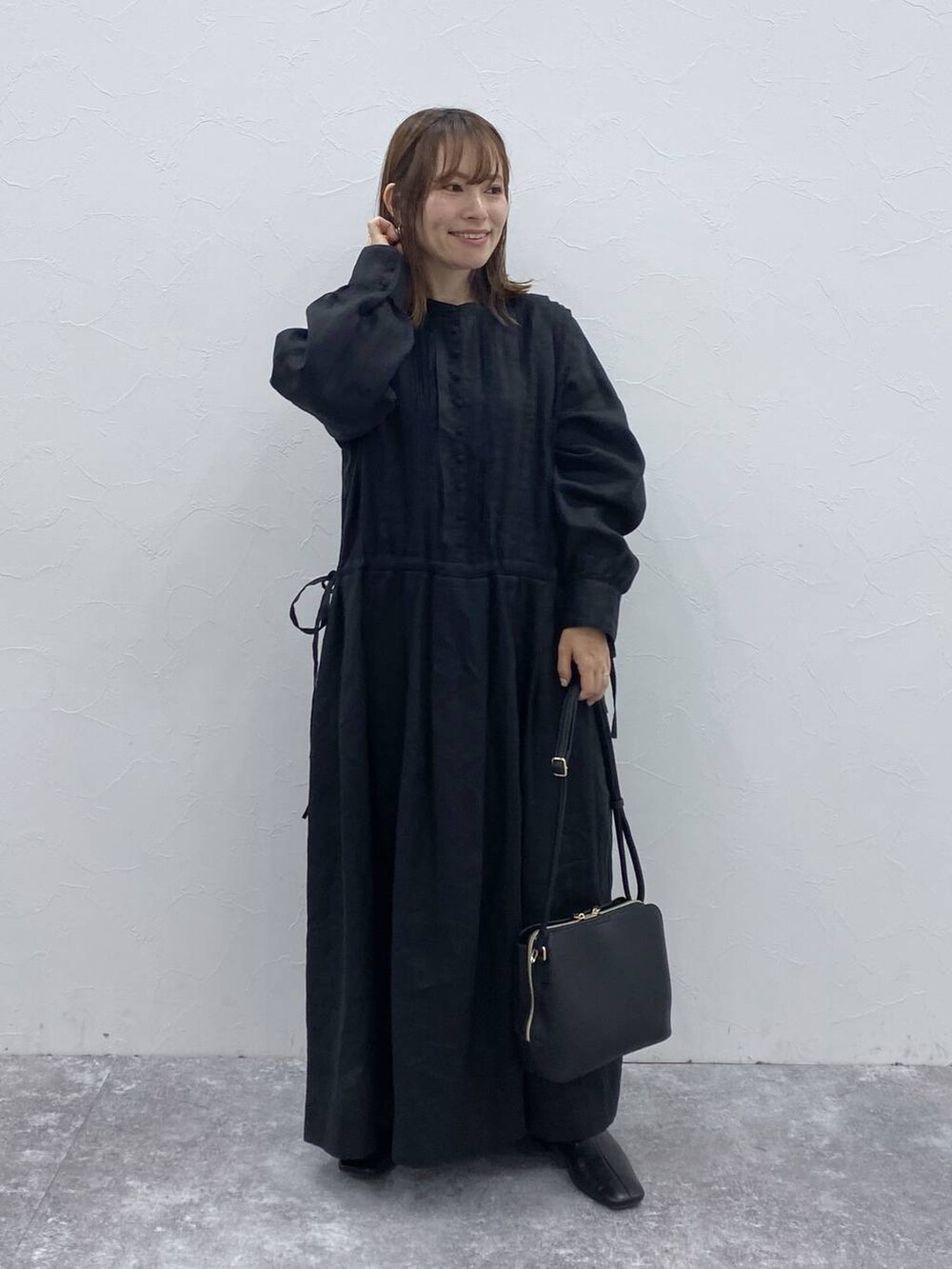 ブラック系のブーツ、ブラック系のショルダーバッグ、ブラック系のワンピースを着用したレディースの夏コーディネートの3枚目の写真