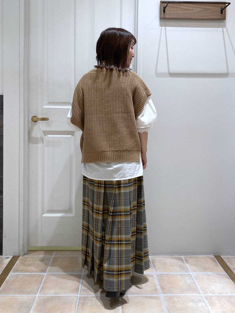 ブラック系のブーツ、ブラウン系のベスト、ホワイト系のシャツ/ブラウスを着用したレディースの秋コーディネートの6枚目の写真