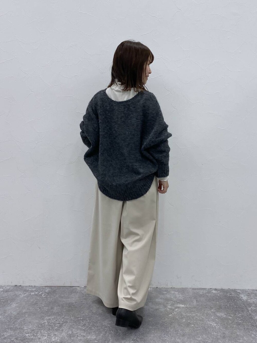 グレー系のTシャツ/カットソー、ブラック系のブーツ、ベージュ系のその他パンツを着用したレディースの冬コーディネートの6枚目の写真