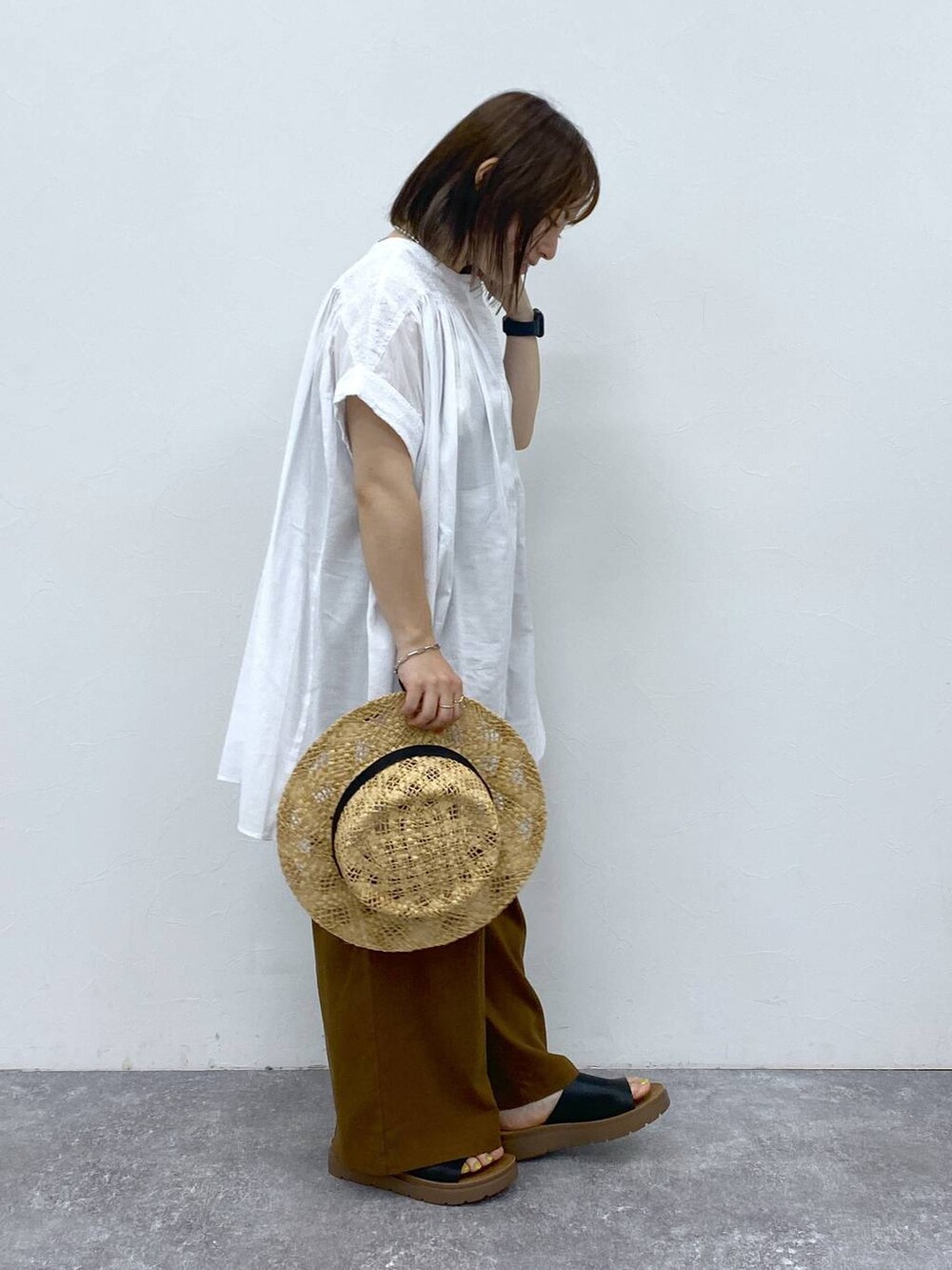 ブラウン系のその他パンツ、ブラック系のサンダル、ホワイト系のシャツ/ブラウスを着用したレディースの夏コーディネートの4枚目の写真