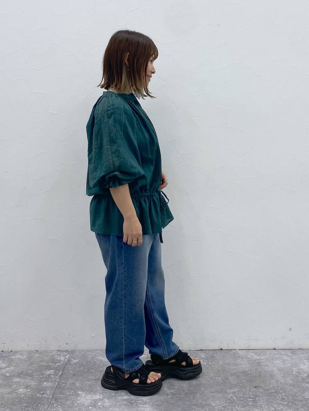 ブルー系のデニムパンツ、ブラック系のサンダル、ブラック系のタンクトップを着用したレディースの夏コーディネートの4枚目の写真