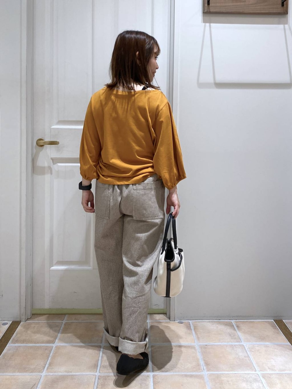 オレンジ系のTシャツ/カットソー、ブラック系のキャミソール、その他のデニムパンツを着用したレディースの夏コーディネートの7枚目の写真