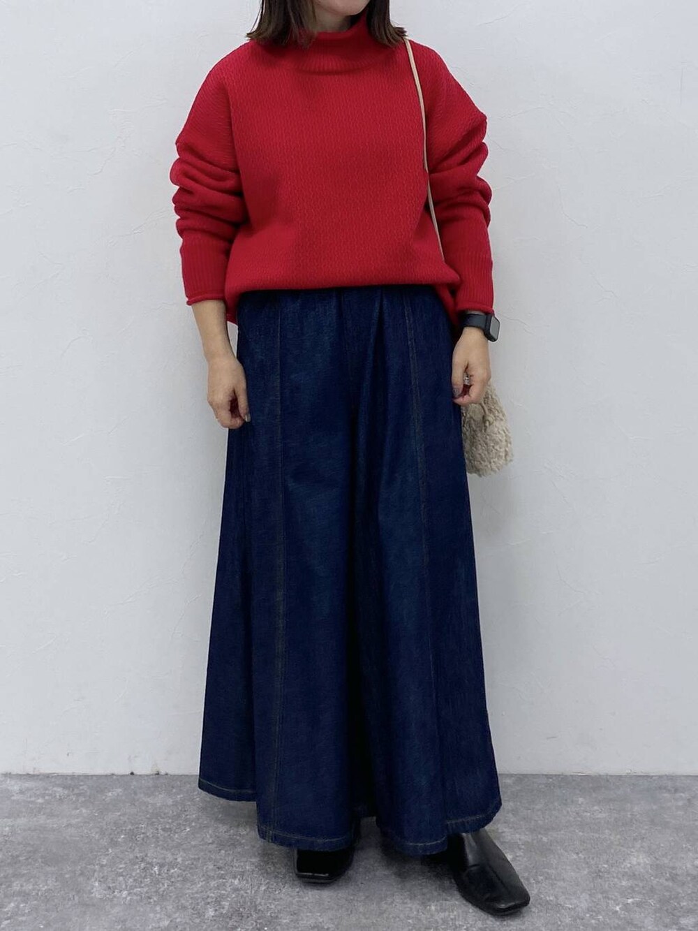 ブルー系のデニムパンツ、ブラック系のブーツを着用したレディースの秋コーディネートの2枚目の写真