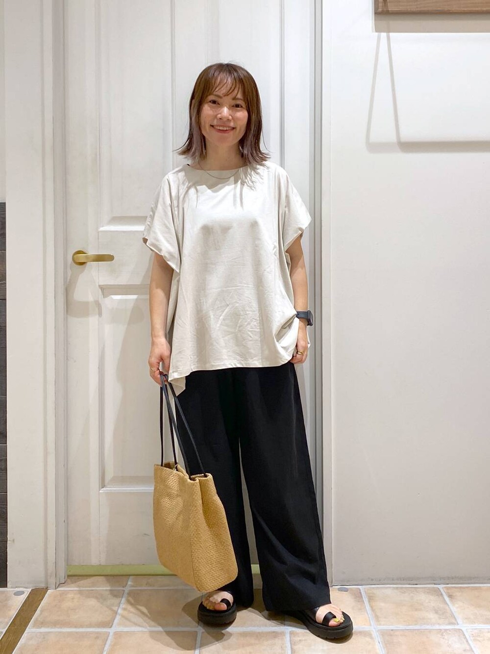 ブラック系のサンダル、ブラック系のその他パンツ、ベージュ系のトートバッグを着用したレディースの夏コーディネートの2枚目の写真