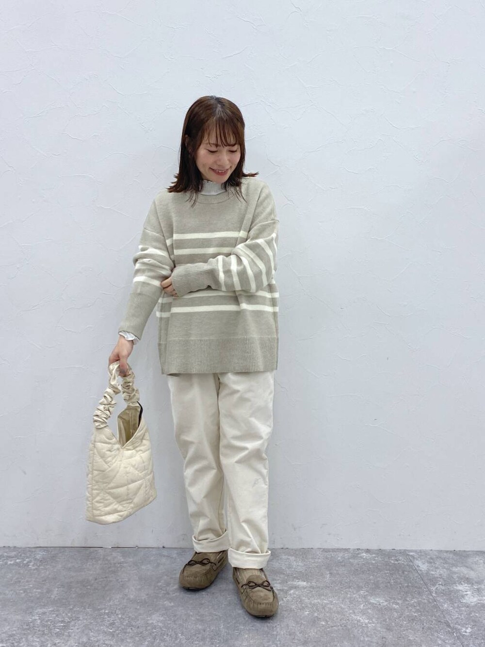 グレー系のTシャツ/カットソー、グレー系のモカシン/デッキシューズ、ベージュ系のトートバッグを着用したレディースの冬コーディネートの4枚目の写真