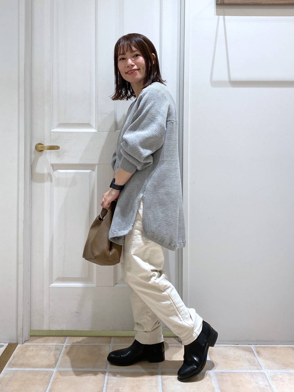 ホワイト系のその他パンツ、ブラック系のブーツ、ブラウン系のショルダーバッグを着用したレディースの秋コーディネートの4枚目の写真