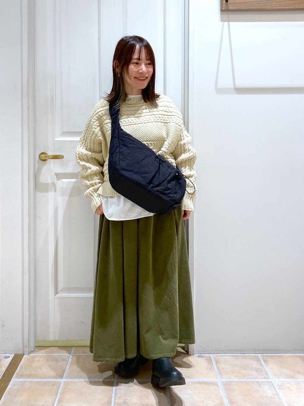 グリーン系のその他パンツ、ブラック系のブーツ、ブラック系のショルダーバッグを着用したレディースの冬コーディネートの3枚目の写真