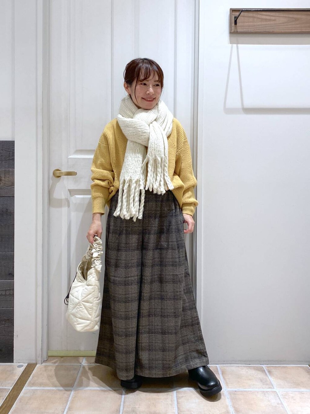 イエロー系のニット/セーター、その他のその他パンツ、ベージュ系のトートバッグを着用したレディースの秋コーディネートの2枚目の写真