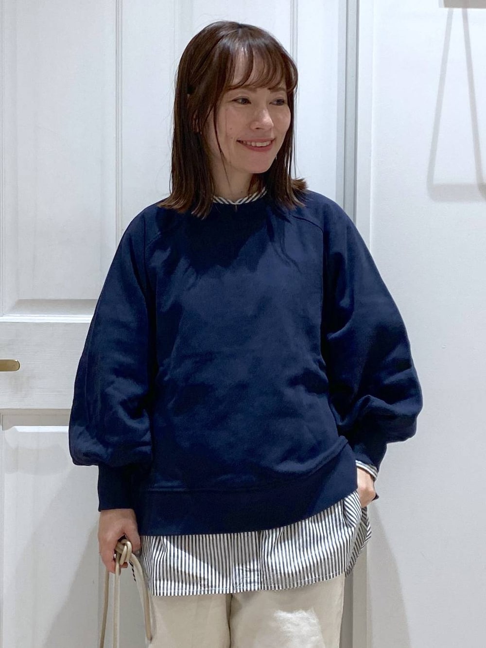 ブルー系のスウェット、ホワイト系のその他パンツ、ブラック系のブーツを着用したレディースの秋コーディネートの3枚目の写真