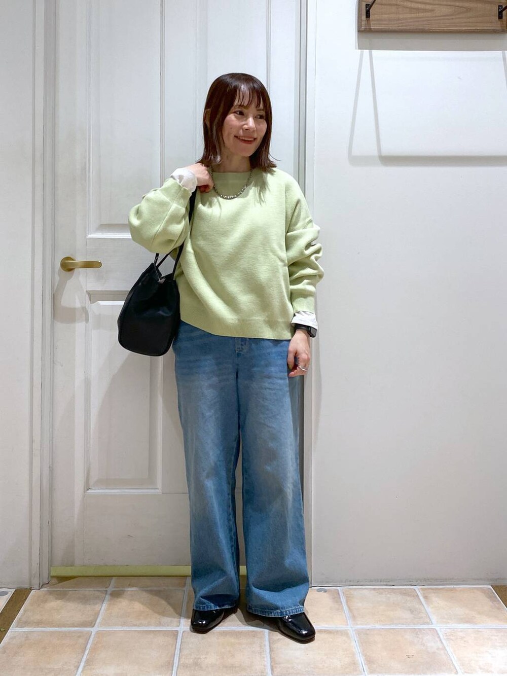 ブラック系のローファー、ブルー系のデニムパンツ、ホワイト系のTシャツ/カットソーを着用したレディースの春コーディネートの3枚目の写真