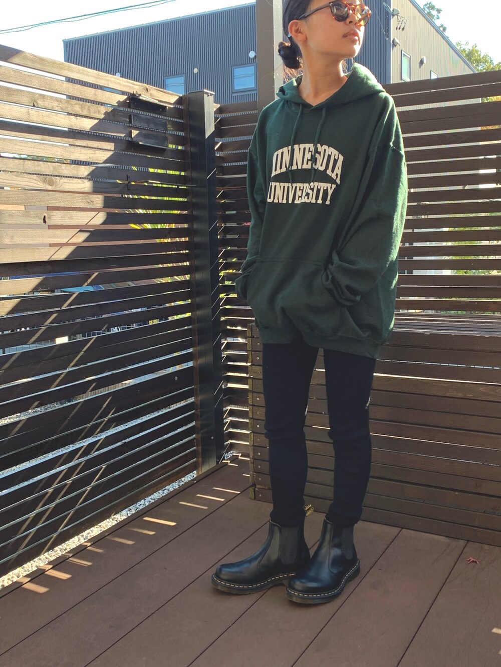 グリーン系のパーカー、ブラック系のブーツ、ブラック系のレギンス/スパッツを着用したキッズの冬コーディネートの3枚目の写真