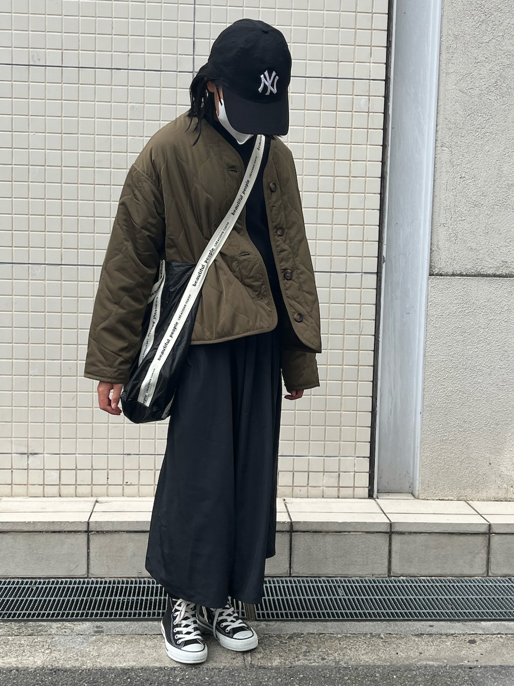 ブラウン系のノーカラージャケット、ブラック系のショルダーバッグ、ブラック系のキャップを着用したキッズの冬コーディネートの2枚目の写真